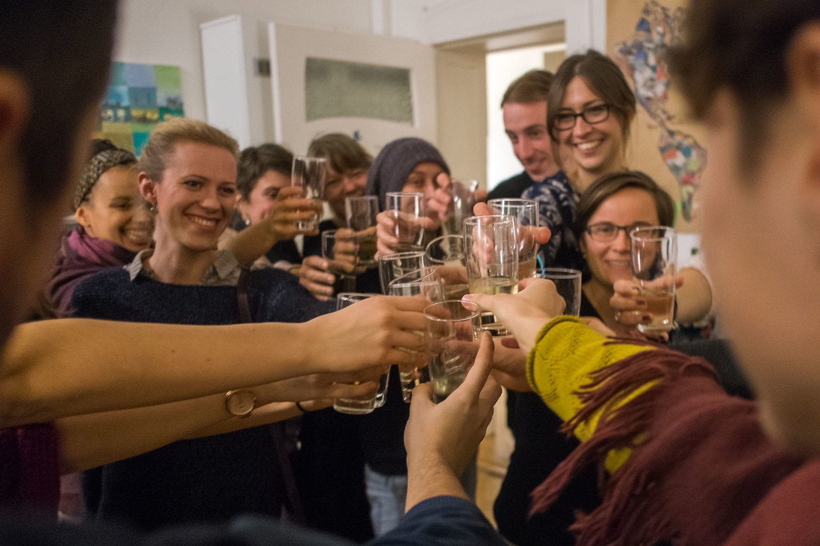 Eine Gruppe von Alumni stößt lachend mit Gläsern an